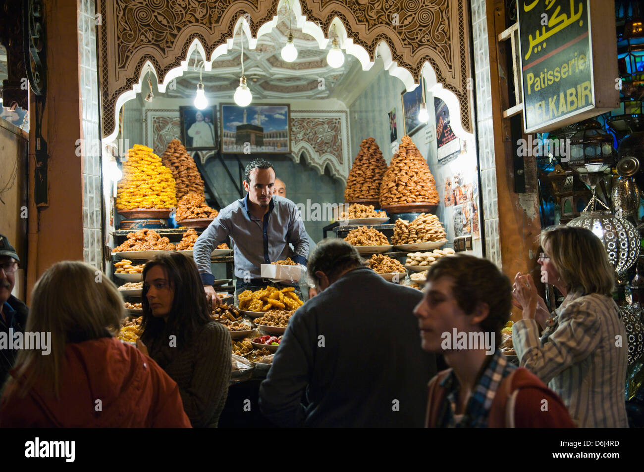 Negoziante vendendo torte dolci ai turisti nei souks di notte, Marrakech (Marrakech, Marocco, Africa Settentrionale, Africa Foto Stock