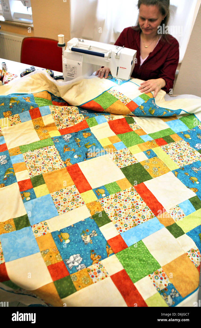 Grit Weigmann cuce un mosaico per bambini coperta nel suo negozio a Halle (Saale), Germania, 13 marzo 2012. Il proprietario del negozio di tessuto in Halle continua il quasi dimenticato oggetti di artigianato di patchwork la trapuntatura. La cucitura è andato fuori moda dopo la riunificazione. Foto: Jan Woitas Foto Stock