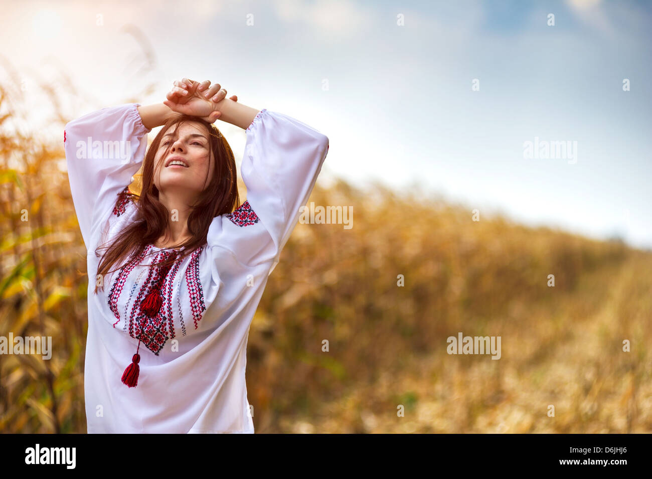 Ritratto di una giovane donna nel tradizionale maglietta ucraino in piedi con cornfield sullo sfondo Foto Stock