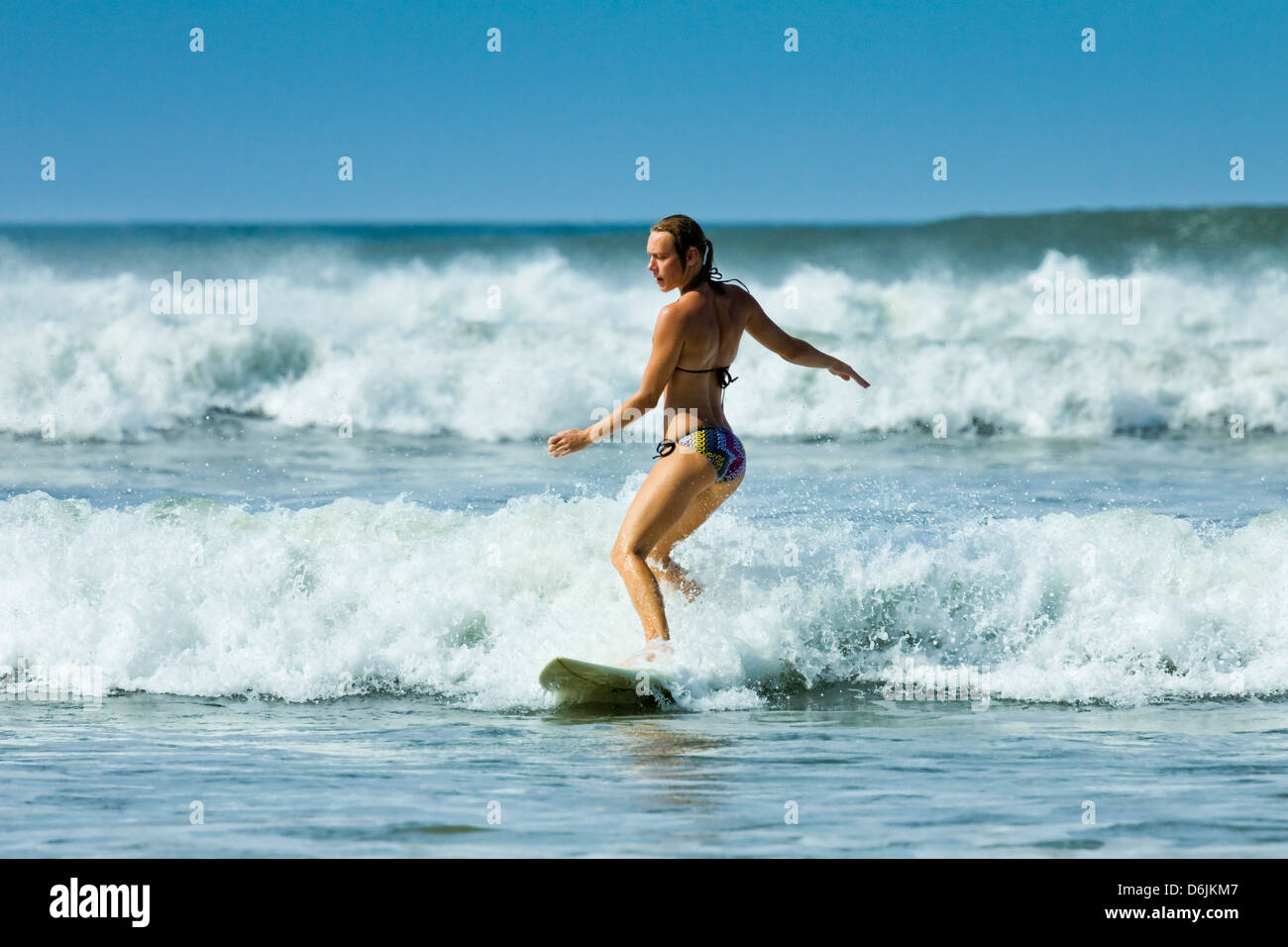 Ragazza il surf in acqua bianca a Playa Guiones beach, Nosara, Nicoya peninsula, provincia di Guanacaste, Costa Rica, America Centrale Foto Stock