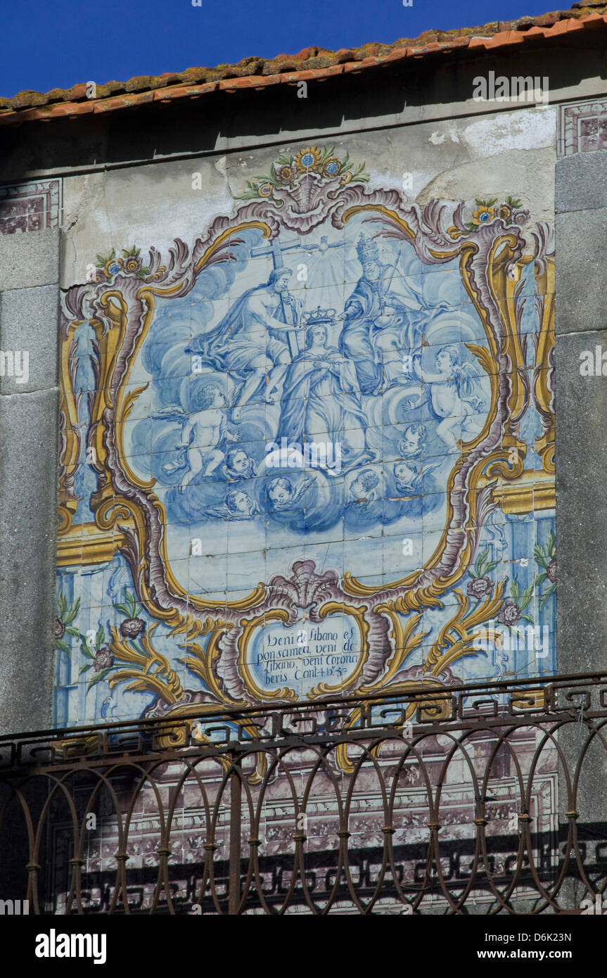 Blu e bianco piastrellate azuleju tableau con elaborati oro telaio piastrellato conservato in un vecchio muro nella città di Oporto, Portogallo Foto Stock