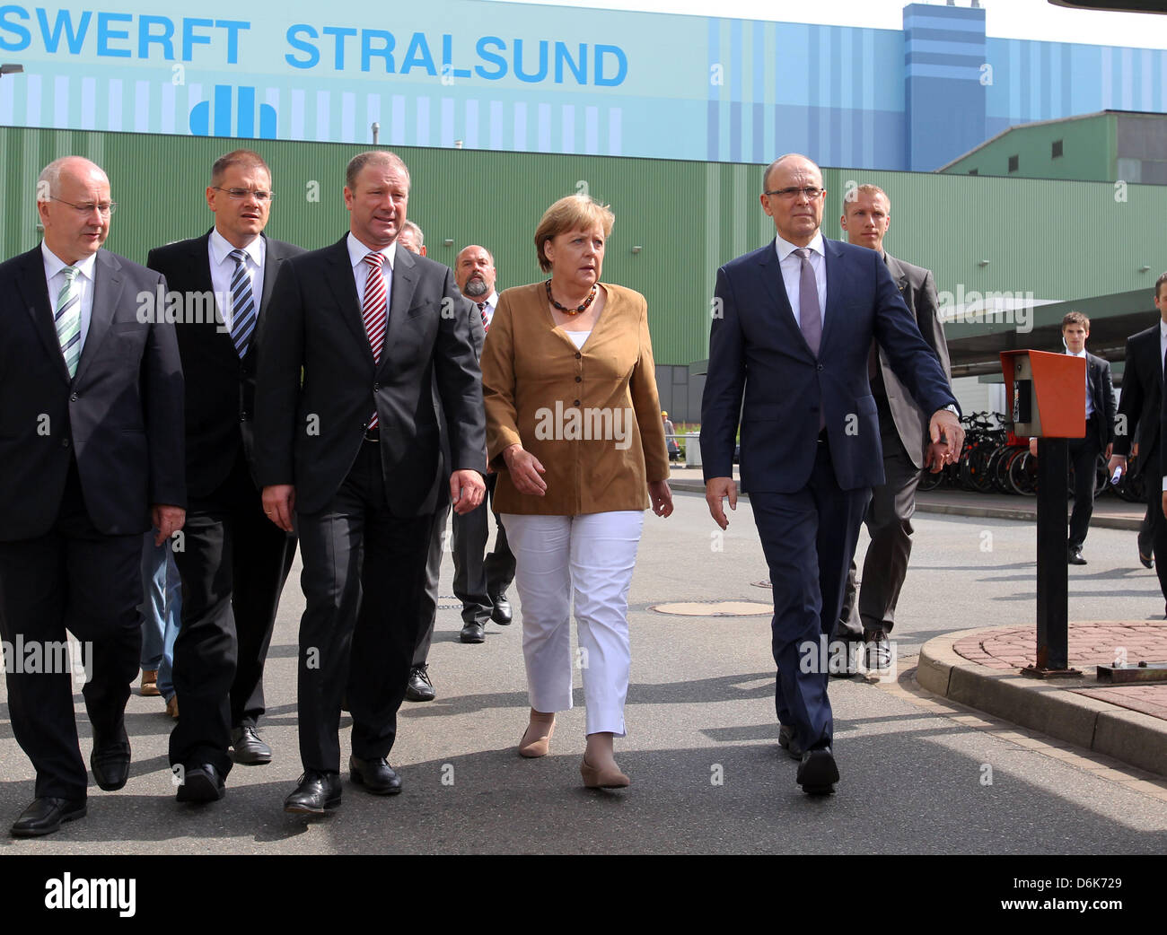 Il cancelliere tedesco Angela Merkel, Premier di Meclemburgo-pomerania Erwin Sellering (R) e Manager di P+S-Werften in Stralsund e Wolgast Ruediger Fuchs (2-L) dare una dichiarazione all'ingresso del cantiere Volksweft a Stralsund, Germania, 21 agosto 2012. Merkel ha preso parte a una riunione sul futuro della società di costruzione navale, dove i rappresentanti dei media non sono ammesse Foto Stock