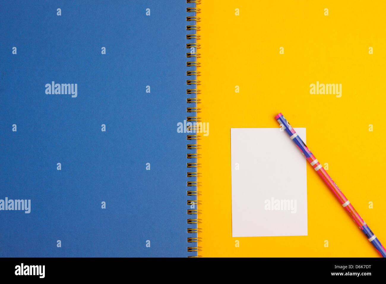 Schermata bianca vuota nota carta e matita con una spirale Libro blu su sfondo giallo Foto Stock