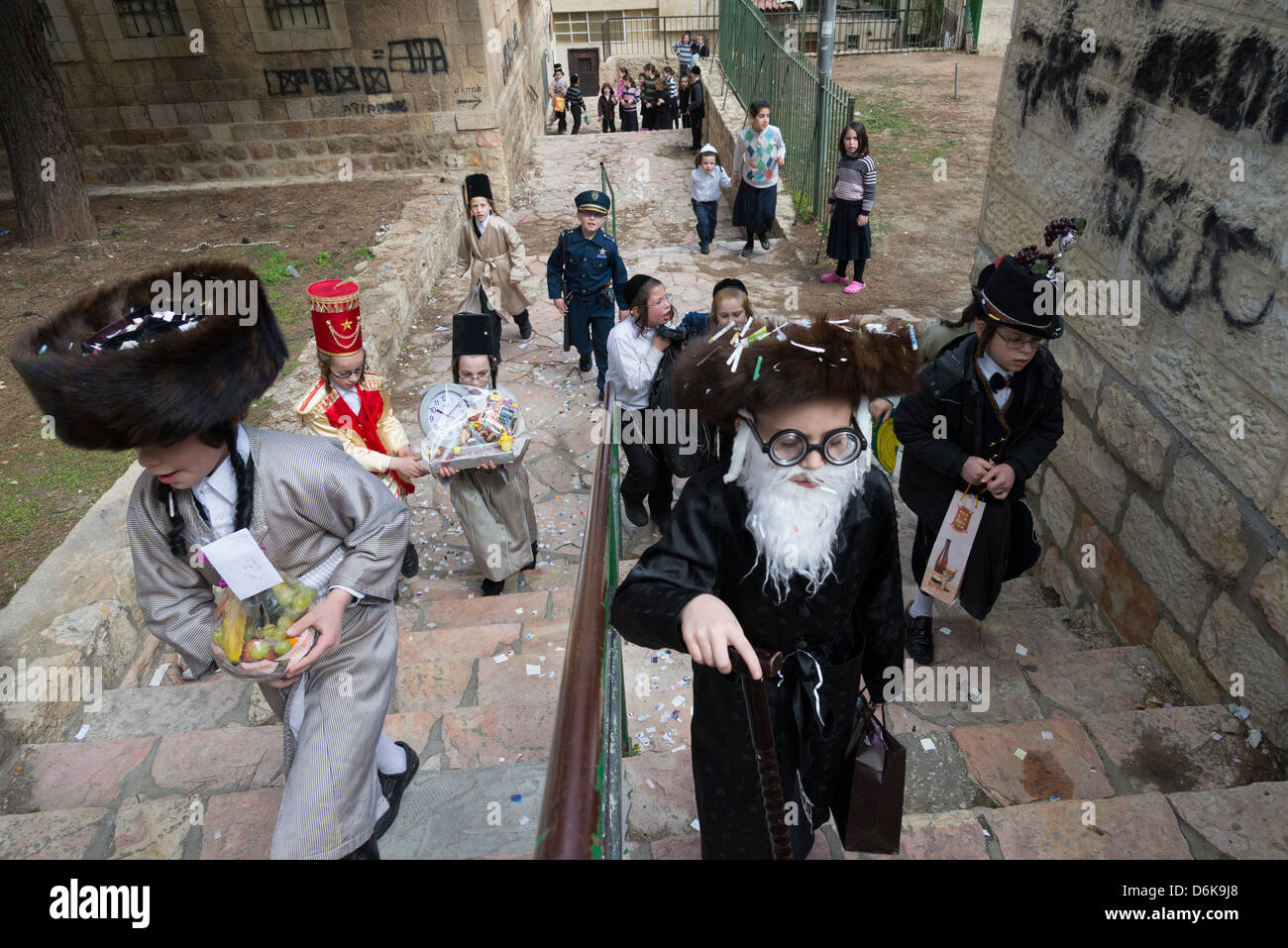 Ebrea ortodossa ragazzi mascherati per la festa di Purim festival per le strade di Mea Shearim. Israele. Foto Stock