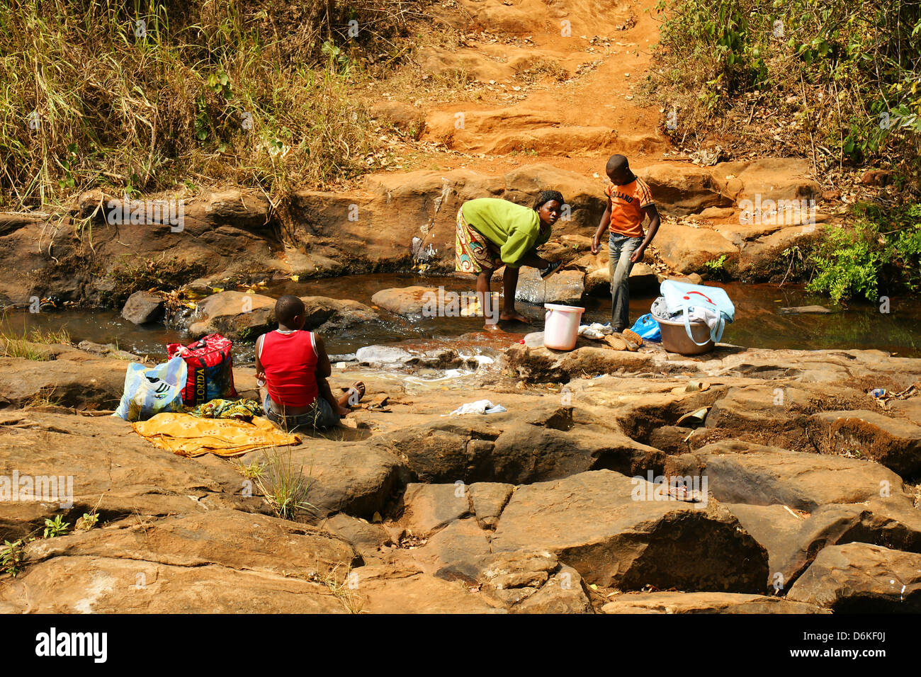 FONGO-TONGO, Camerun - gennaio 20: giovane donna africana con giovani uomini a lavare i panni in un fiume su gennaio 20, 2013 in Cameroo Foto Stock