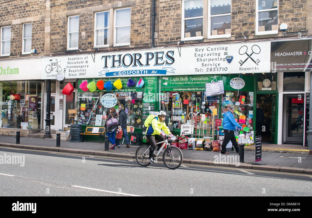 Ciclista passato di equitazione Thorpes hardware shop London high street North East England Regno Unito Foto Stock