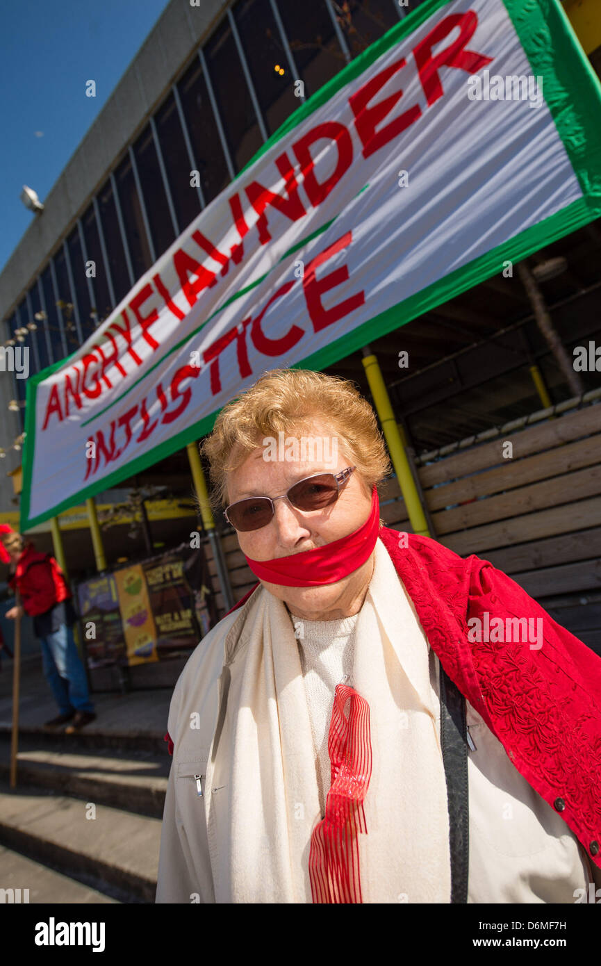 Aberystwyth Wales UK. Xx Aprile, 2013. Oltre 600 persone si sono radunate per circondare Aberystwyth Arts Center in una veglia silenziosa a metà giornata di oggi a sostegno dei sospesi i membri del personale e in segno di protesta per presunte minacce internazionalmente rinomato centro a seguito della ristrutturazione a Aberystwyth University. A seguito di una campagna su Facebook molte delle persone in veglia indossavano rosso, e alcuni di essi avevano gags oltre le loro bocche, per evidenziare la presunta "gagging ordini" che sono state applicate per i membri del personale del centro per impedire loro di commentare la situazione. Credito: Keith Morris/Alamy Liv Foto Stock