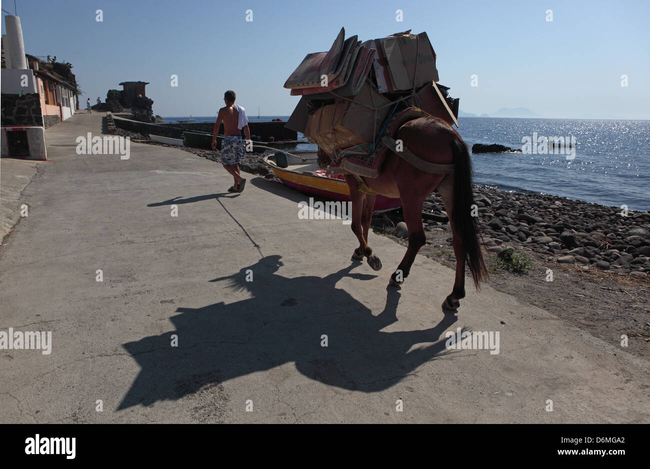 Alicudi, l'Italia, laden mulo getta un'ombra sulla strada Foto Stock