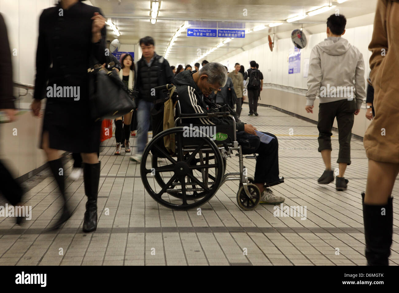 Hong Kong, Cina, mendicante si siede nella sua sedia a rotelle in un Fussgaengertunnel Foto Stock
