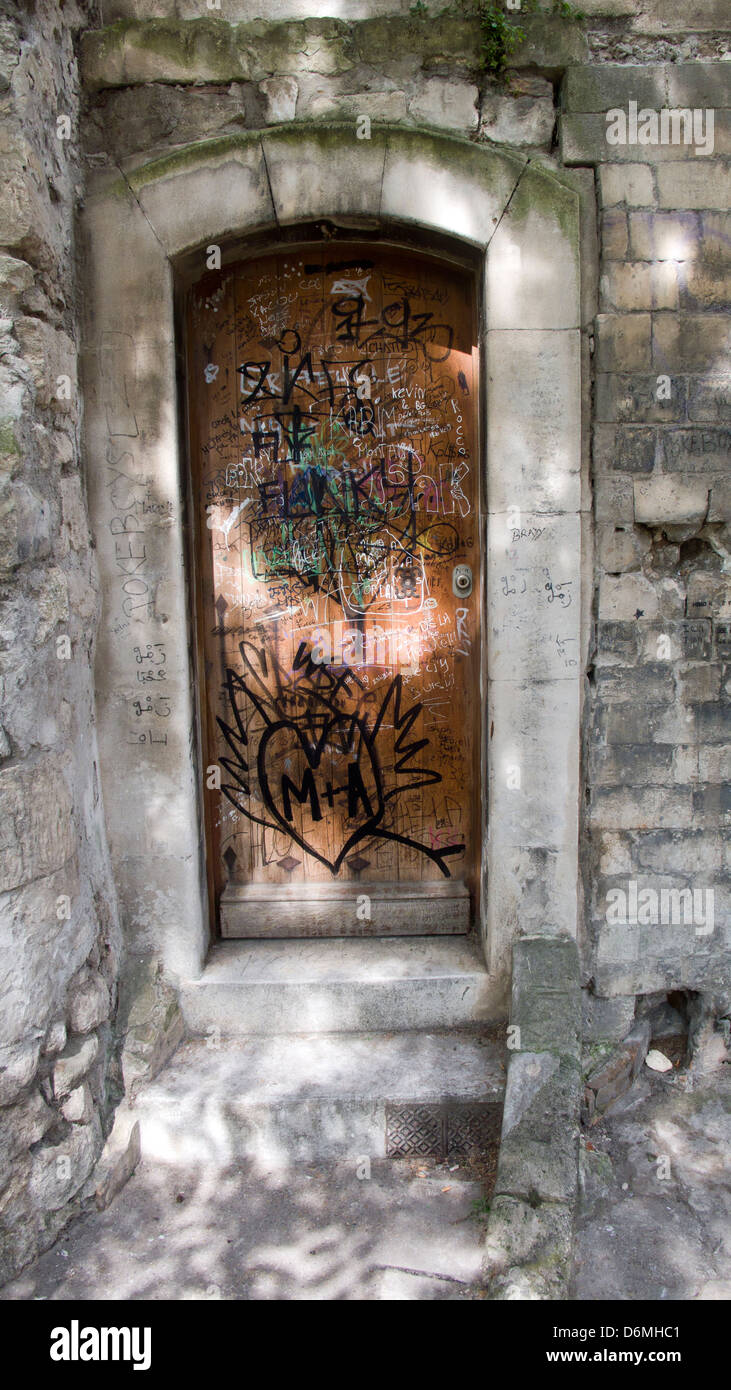 La luce del sole sulla porta di graffiti, antico muro di pietra, Arles, Provenza Foto Stock