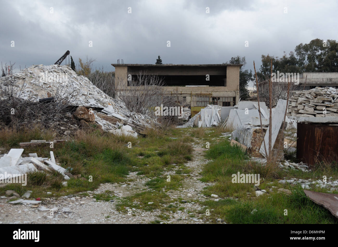 Fabbrica abbandonata esterno e pila di marmo di rottami e residui industriali. Foto Stock