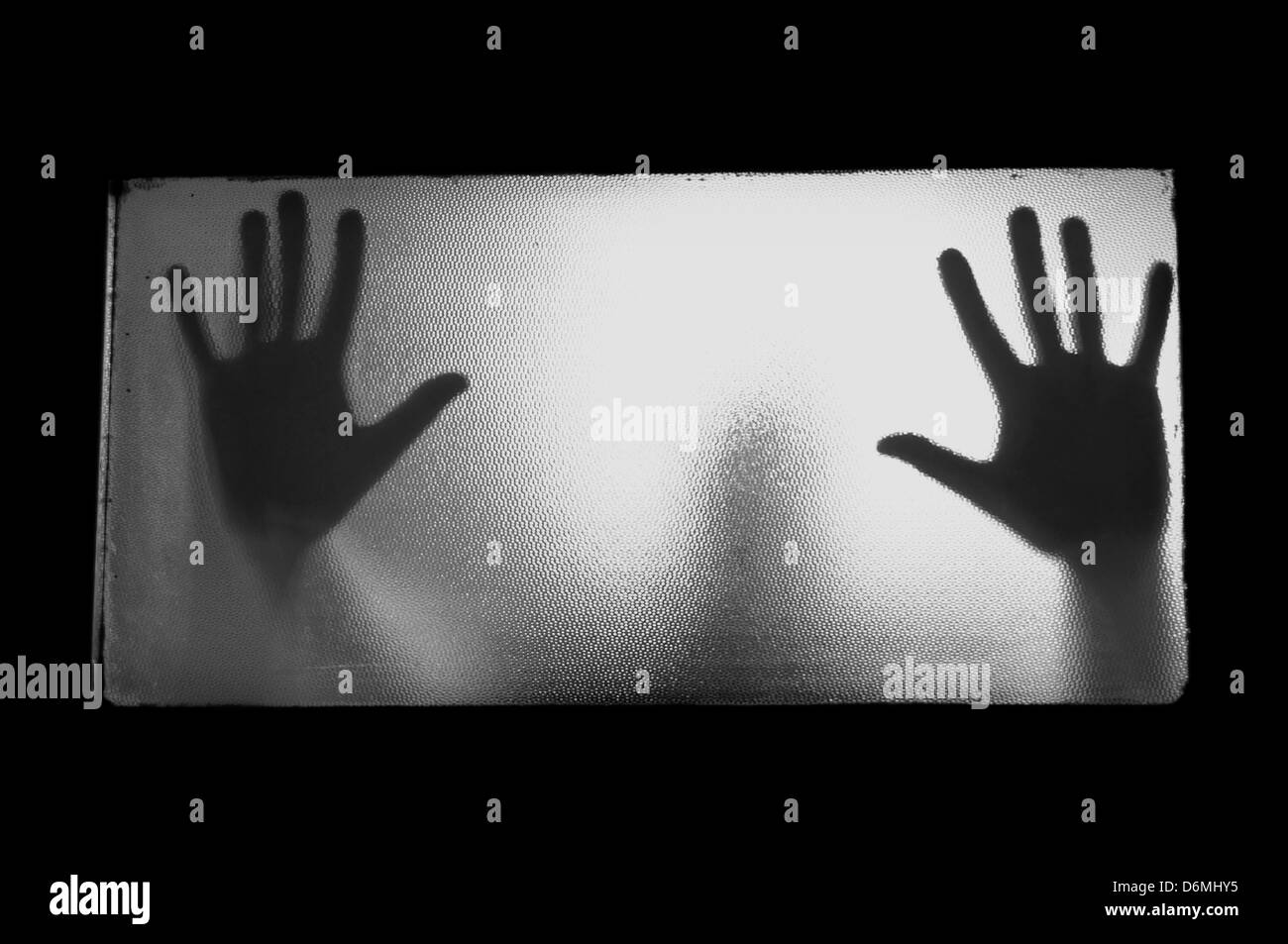 Spooky uomo dietro il vetro. Mani e sfocata figura umana astrazione. Foto Stock