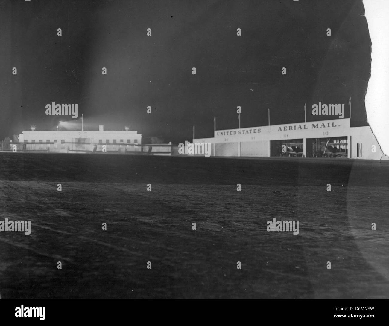 Questa fotografia del 1921 mostra una vista notturna di un aeroporto di Los Angeles non identificato. L'immagine offre uno sguardo alla storia dell'aviazione, mostrando le infrastrutture e l'illuminazione utilizzate per le operazioni notturne durante gli anni formativi del volo commerciale e militare. Foto Stock