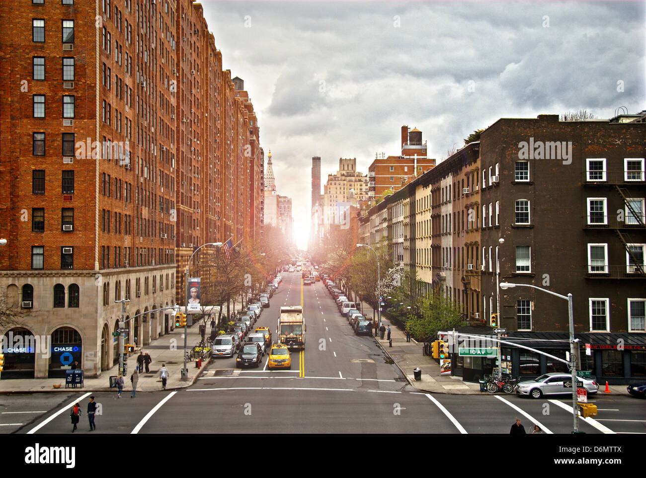 Una vista del sole brillante alla fine di una strada nel quartiere di Chelsea di New York City, come si vede dalla linea alta Foto Stock
