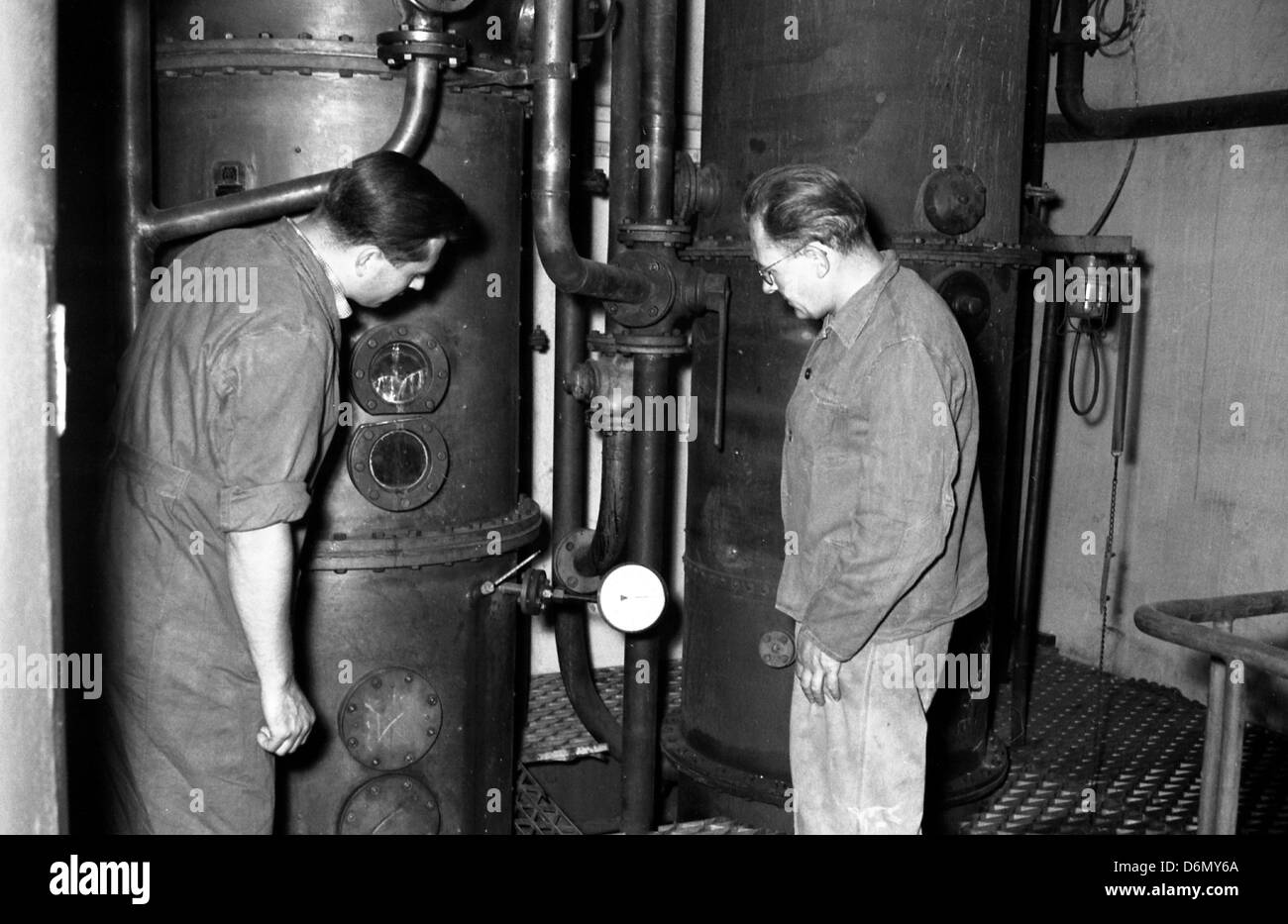 A Dresda, gdr, lavoratori devono affrontare due Destillationsoefen negli spiriti fabbrica VEB Bramsch Dresda Foto Stock