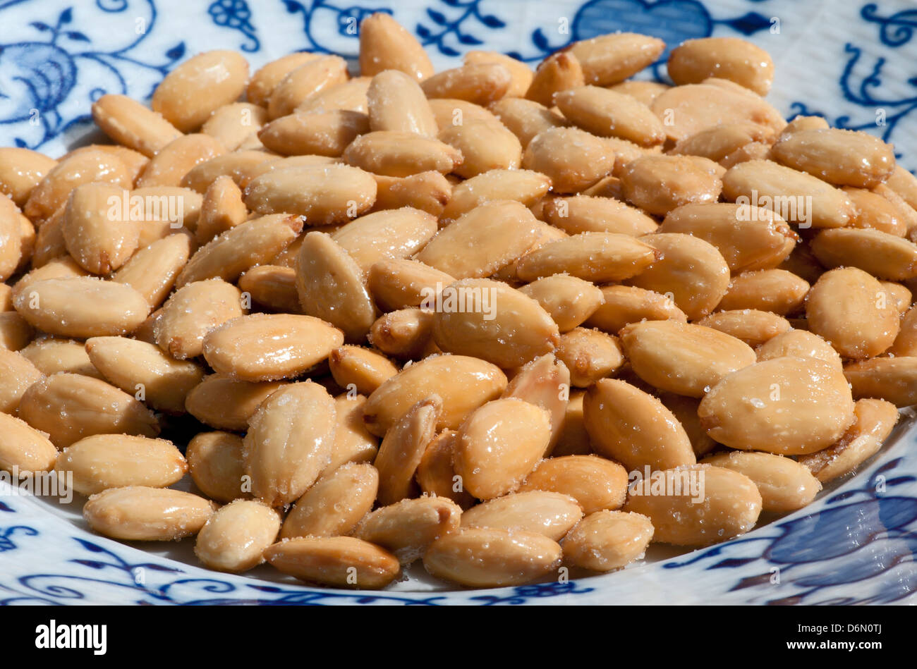 Almond - dadi, fritti salati mandorle sulla piastra Foto Stock
