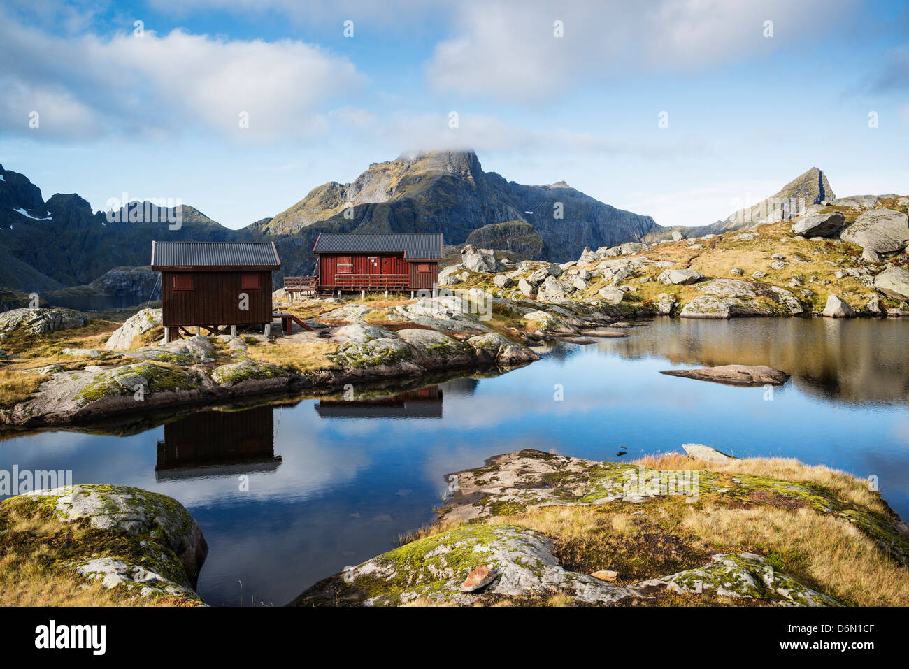 Munkebu baita di montagna con Hermannsdalstinen picco in distanza, Moskenesøya, Isole Lofoten in Norvegia Foto Stock