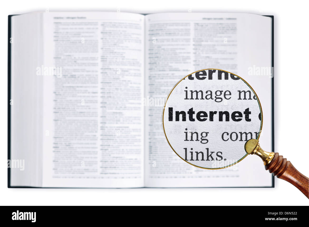 Una lente di ingrandimento detenute nel corso di un dizionario guardando la parola allargata a Internet Foto Stock
