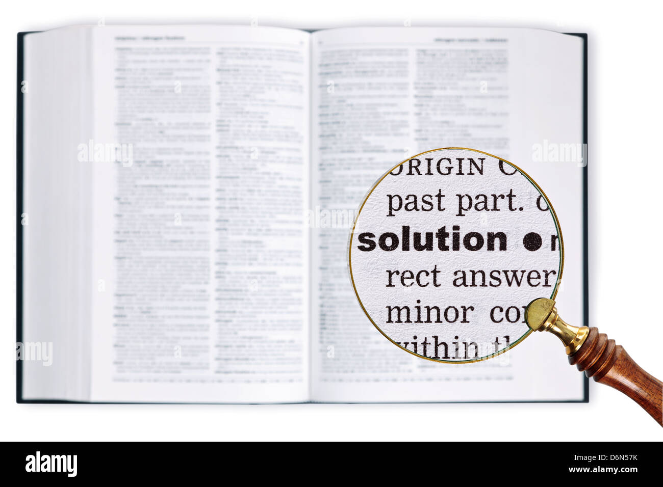 Una lente di ingrandimento detenute nel corso di un dizionario guardando la soluzione word ingrandito Foto Stock