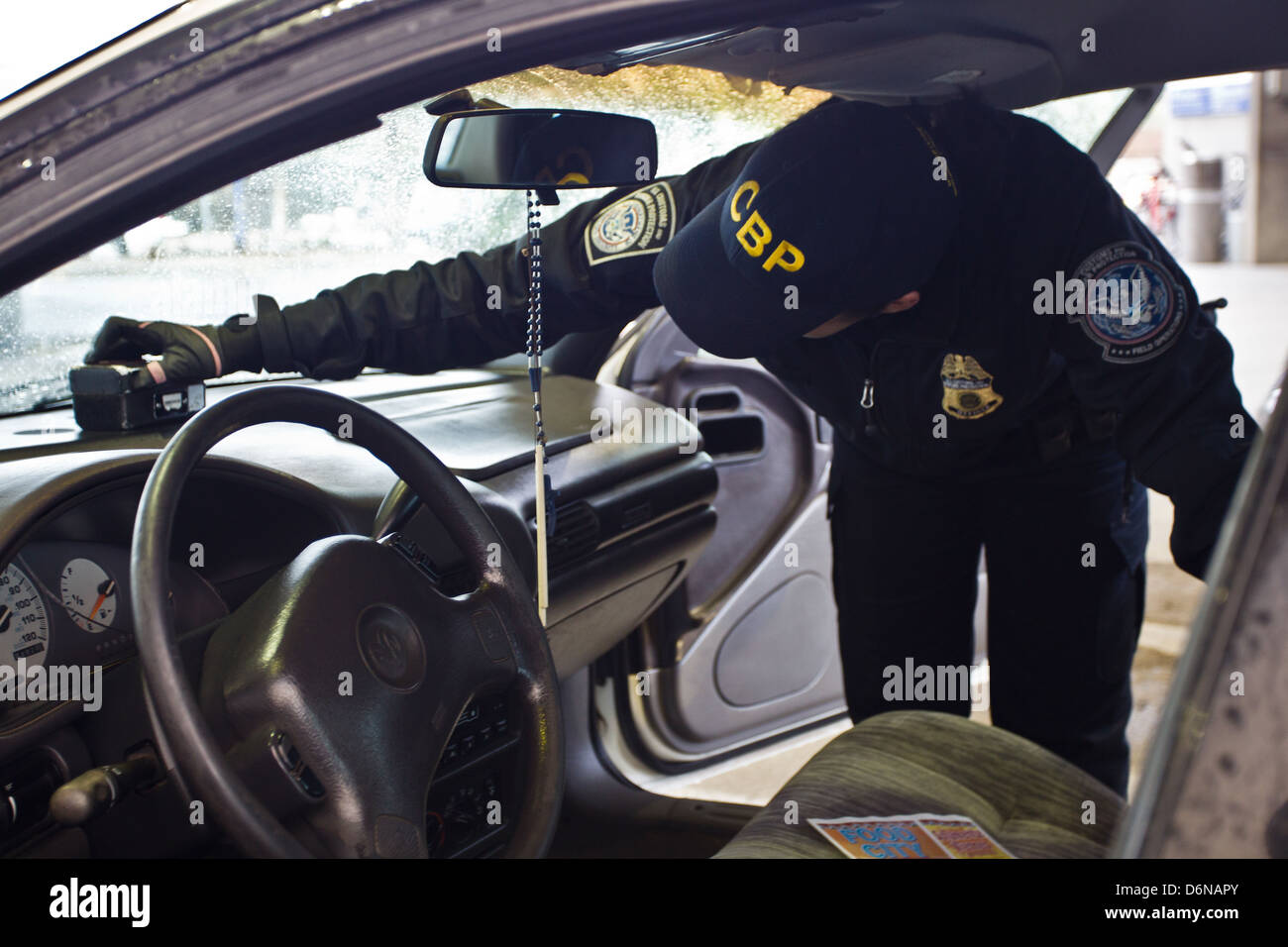 Un US Customs and Border Protection Officer utilizza un contrabbando di dispositivo di rilevamento noto come un buster per ispezionare un veicolo al San Luis border crossing 16 febbraio 2012 a San Luis, AZ. Foto Stock