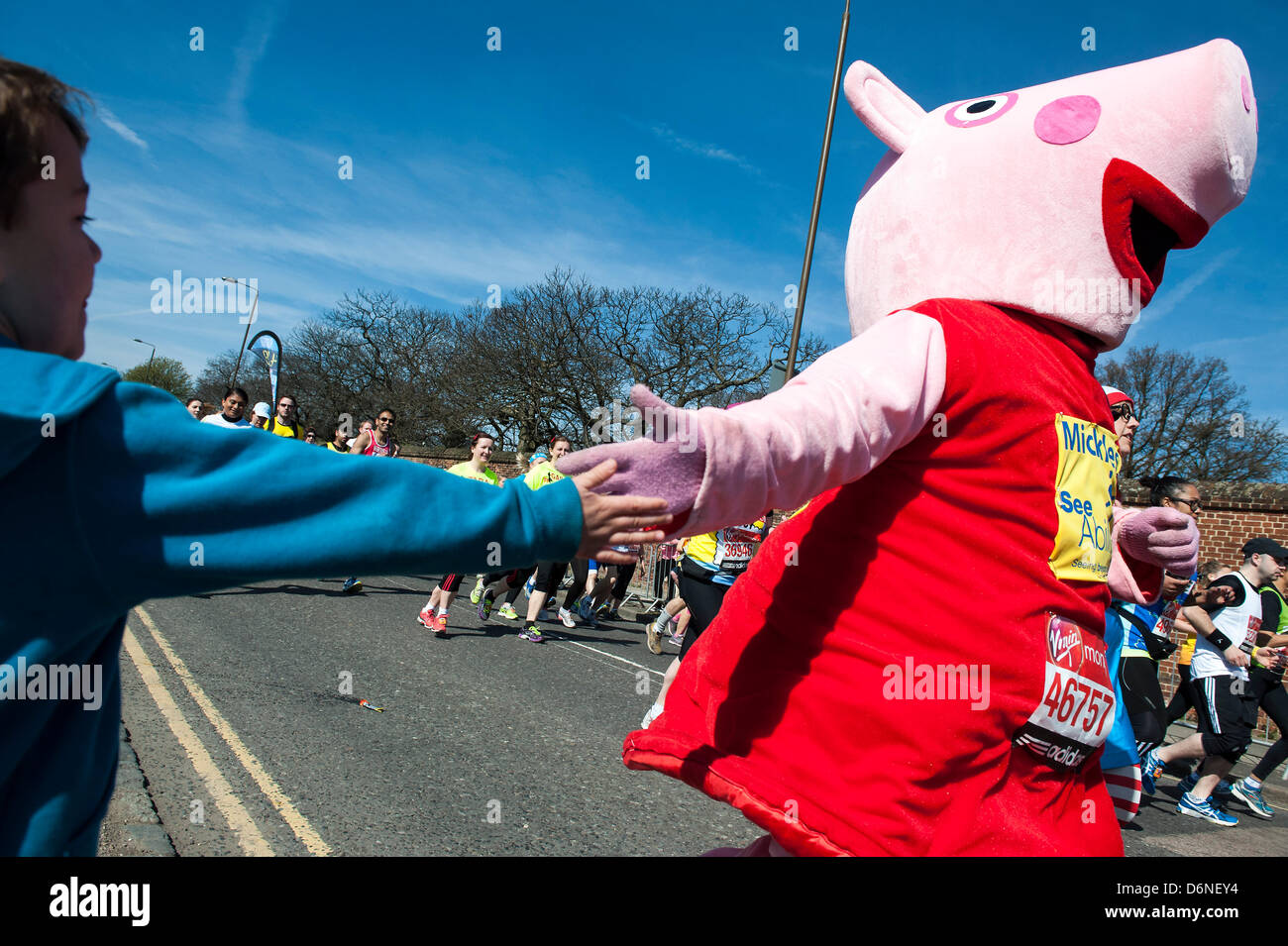 Londra, Regno Unito. Xxi Aprile, 2013. Un ragazzo attende il suo papà e riempie il suo tempo ad alta fiving altri runner, compresi Snow White, un suino e un panda. La Virgin London Marathon da Greenwich al Mall via Canary Wharf. Greenwich Londra, UK, 21 aprile 2013. Foto Stock