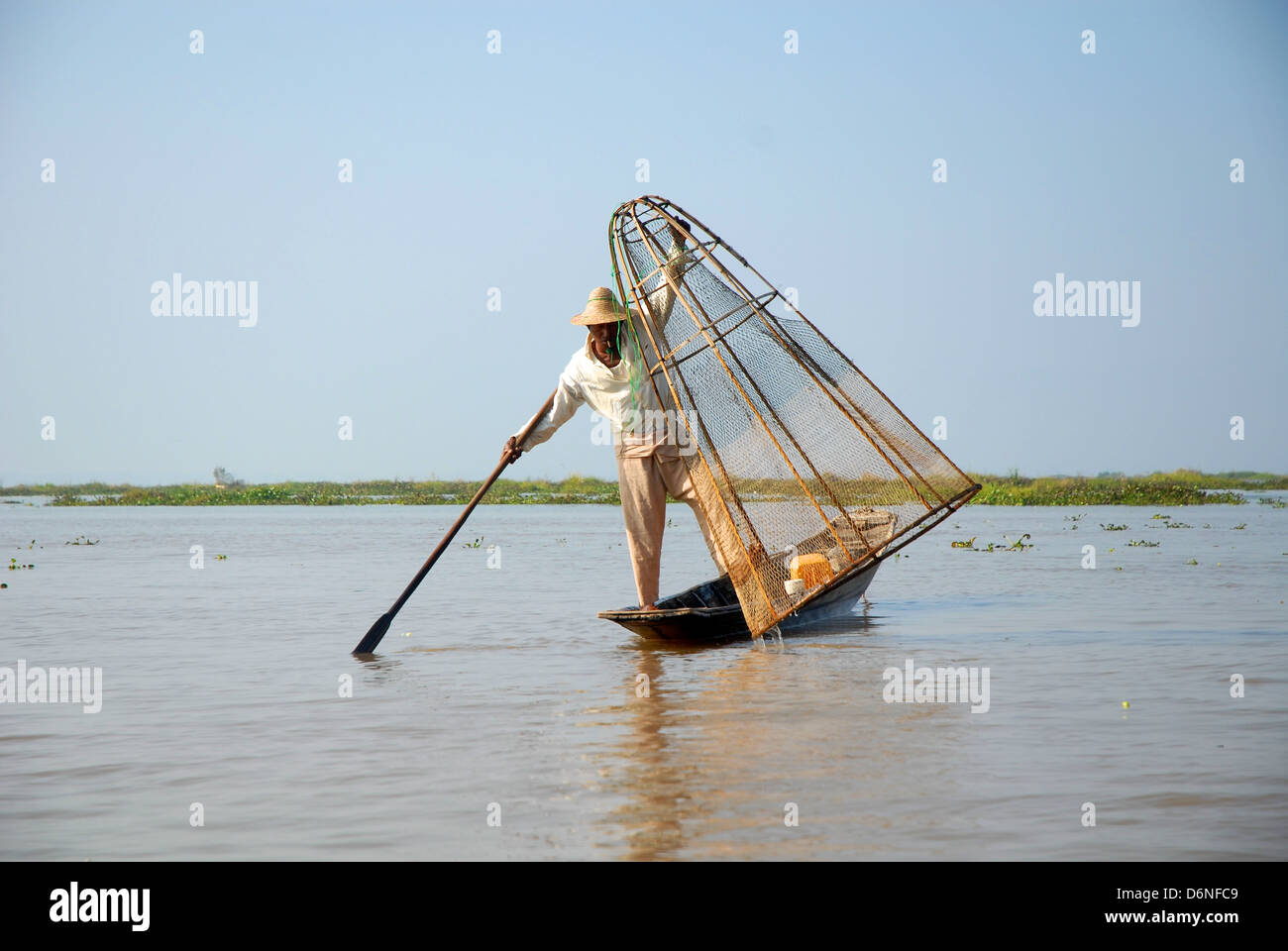 Pescatore sul Lago Inle in Myanmar la pesca con la tradizionale forma conica net. Foto Stock