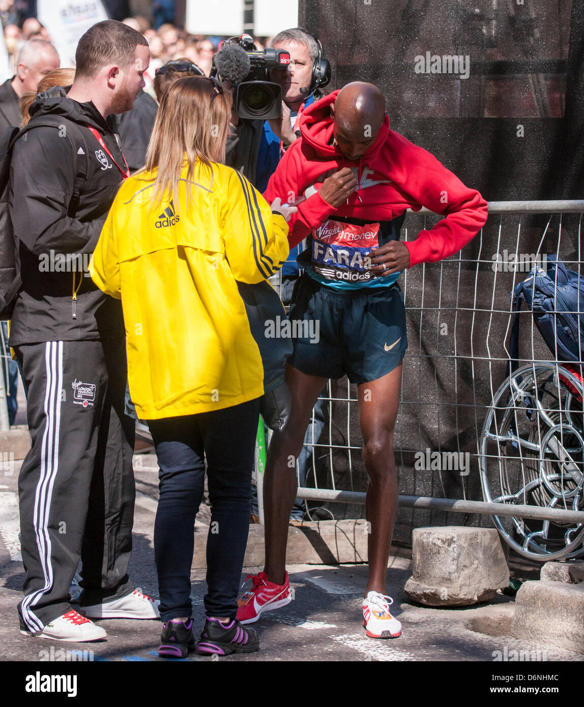 Londra, East Smithfield, 21 aprile 2013. Mo Farah, somale nato e Team GB di Olimpiadi doppia medaglia nel 5,000m e 000m a Londra 2012, indossa il suo sponsor felpa dopo aver terminato la sua corsa, appena prima di miglio 13. Prima della gara Farah aveva detto che egli ha voluto restare con la Elite Uomini Maratona fino a metà strada e ha fatto proprio questo. Foto Stock