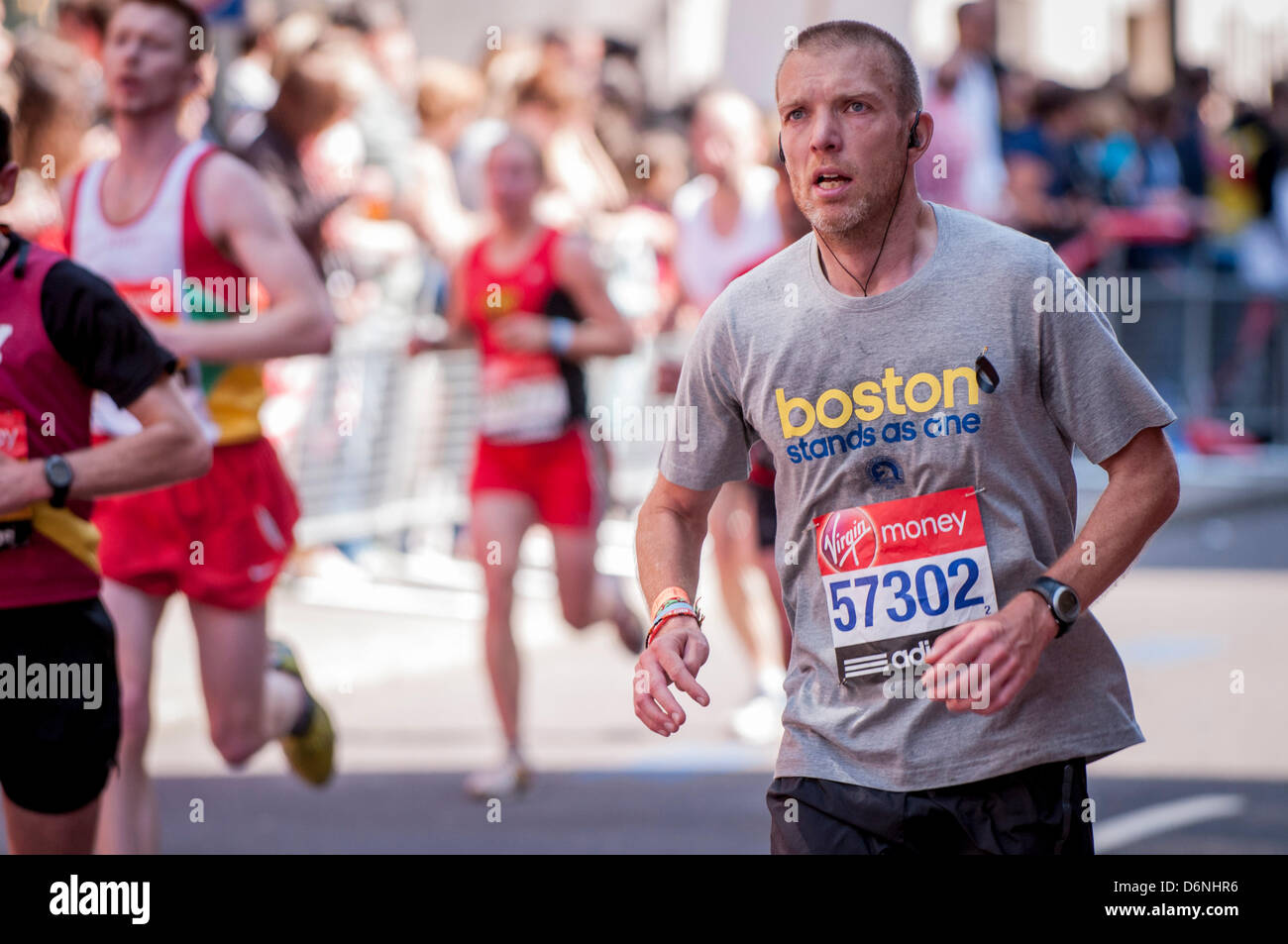 Londra, Lower Thames Street, 21 aprile 2013. 57302 concorrente nella Virgin London Marathon, indossa una maglietta e un nastro nero sostegno alle vittime della maratona di Boston suicida che ha avuto luogo a cinque giorni in precedenza. Foto Stock