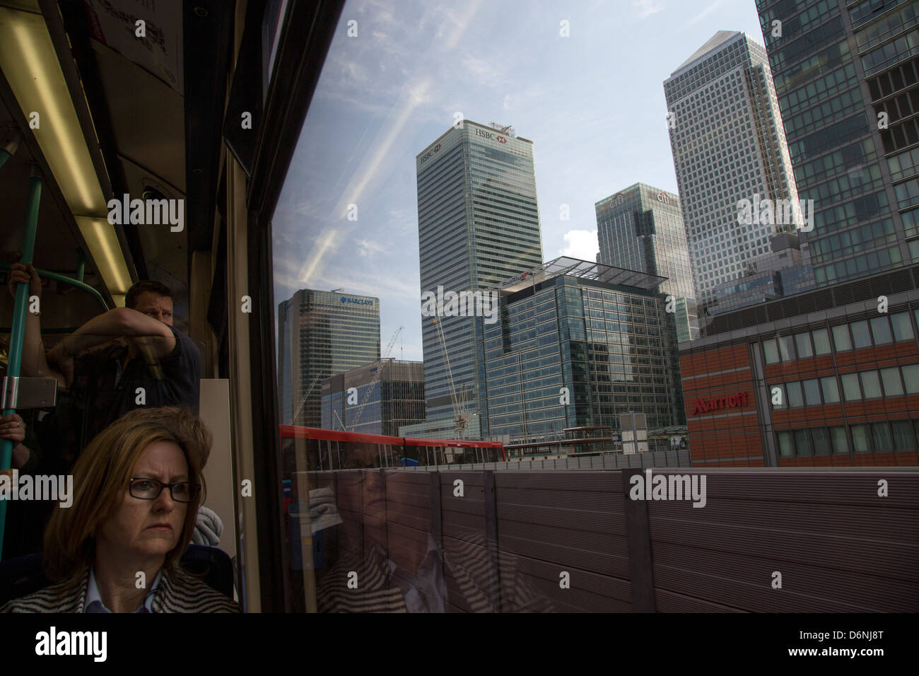 Docklands Light Railway DLR donna che viaggia con Canary Wharf grattacieli vista al di fuori della finestra Foto Stock