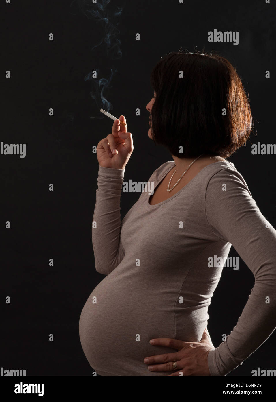 Freiburg, Germania, una donna in stato di gravidanza con una sigaretta accesa Foto Stock