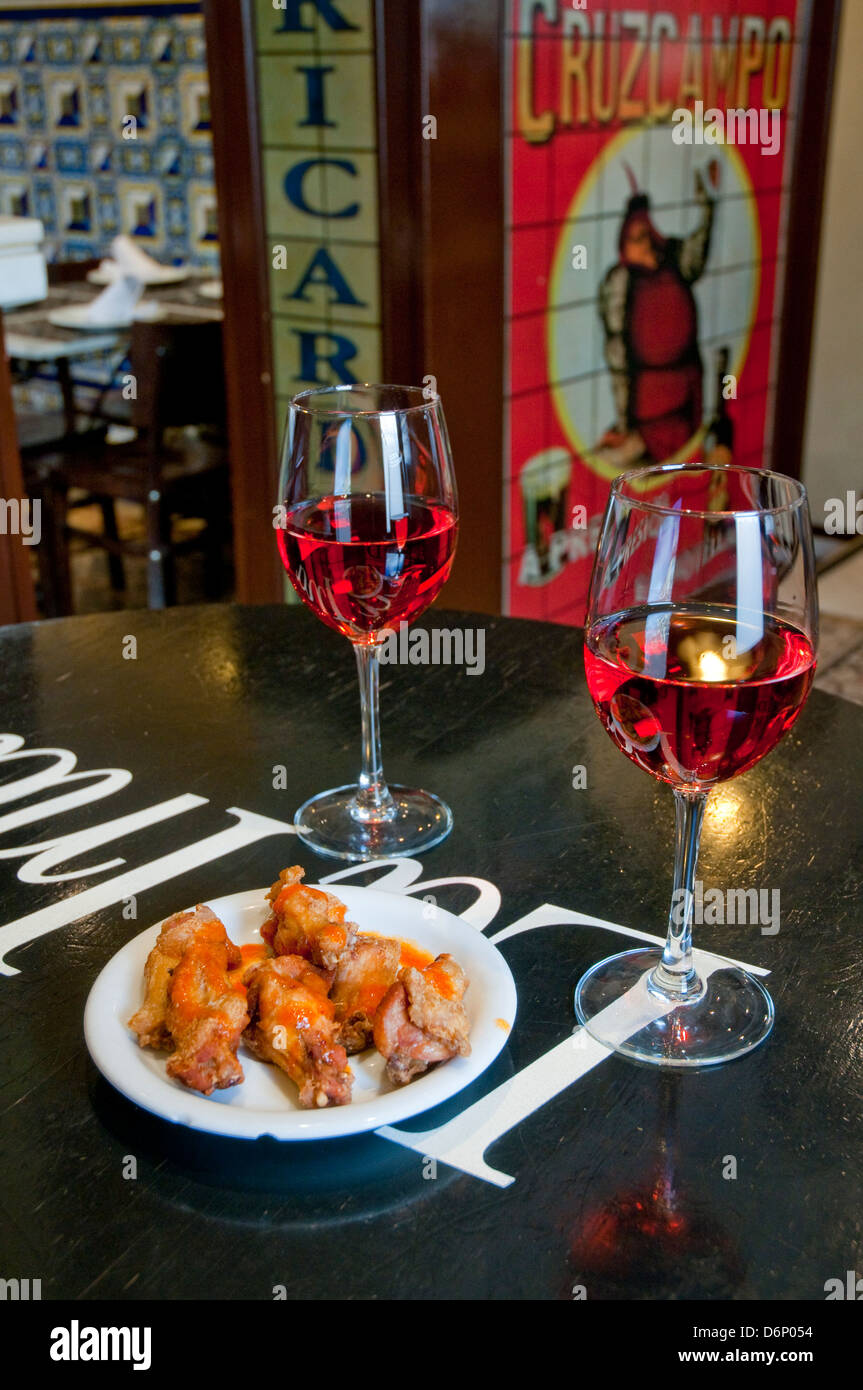Aperitivo spagnolo: due bicchieri di vino rosato e tapas di pollo fritto.. Spagna. Foto Stock