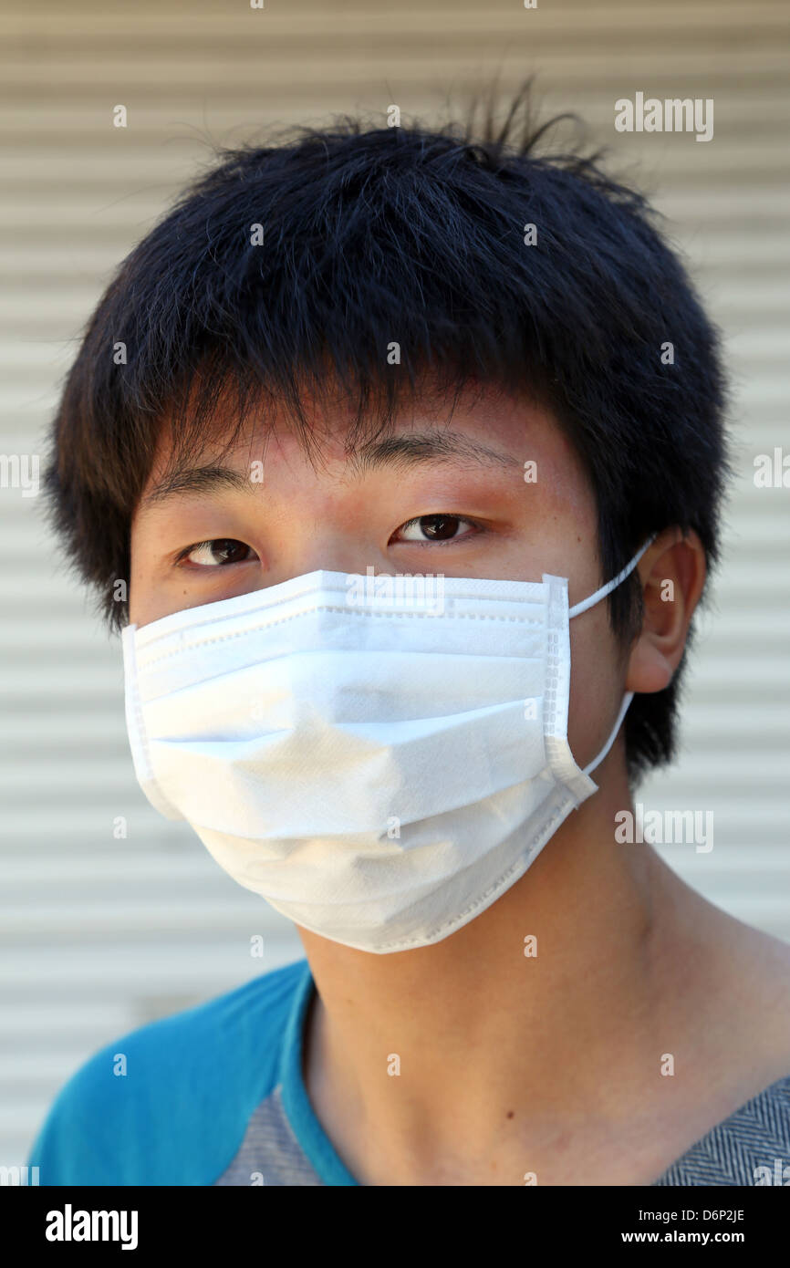 Uomo giapponese indossa una maschera facciale protettiva, Tokyo, Giappone Foto Stock