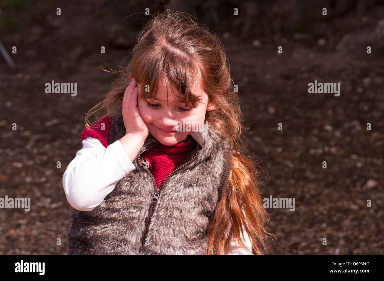 5 anno vecchia ragazza con capelli lunghi marrone vestito in abiti caldi al di fuori Foto Stock