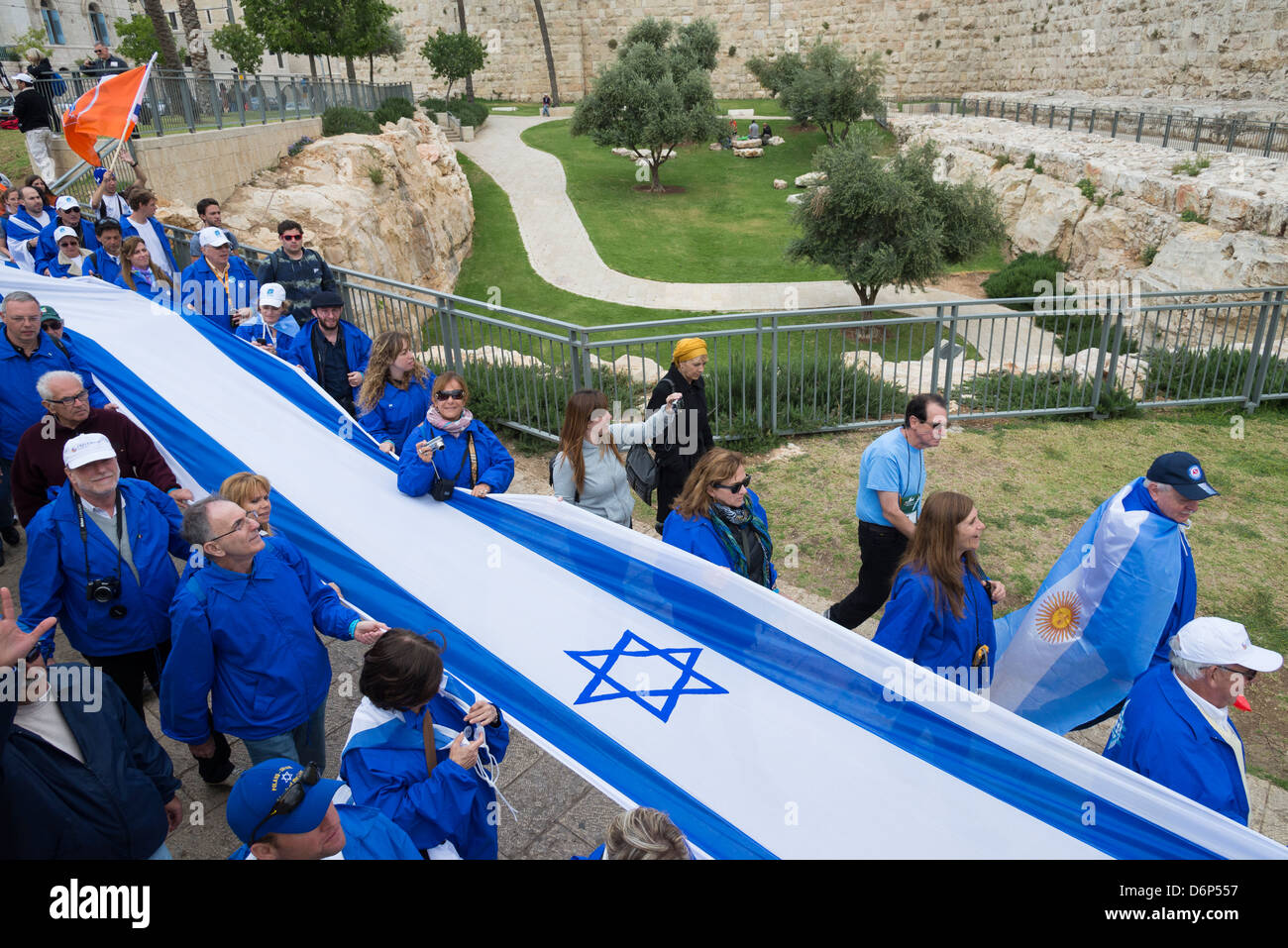 Folla in marcia con una lunga bandiera israeliana intorno alle mura della citta'. Gerusalemme la città vecchia. Israele. Foto Stock