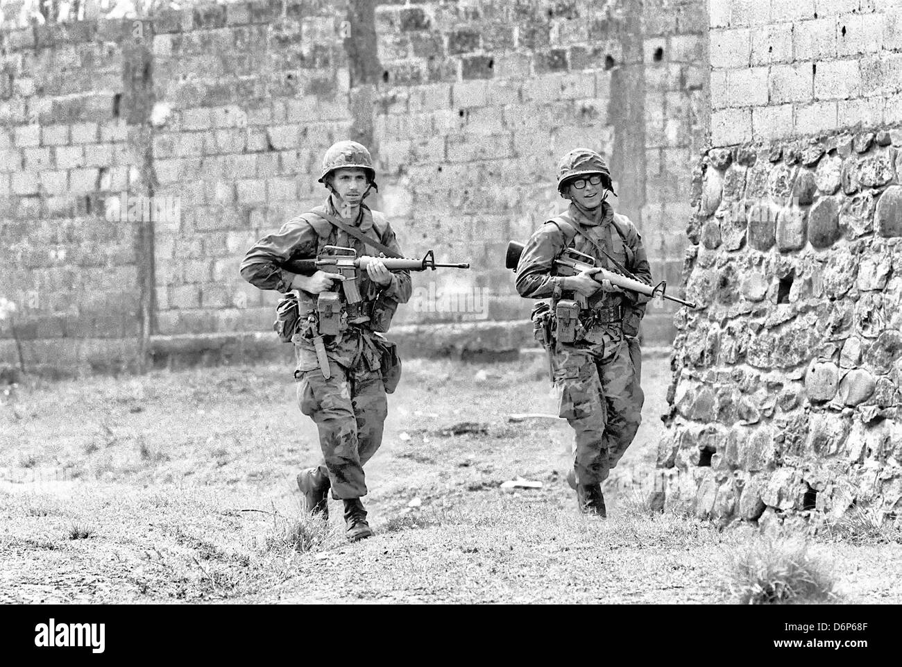 Marines americani armati con M16A1 pattuglie di fucile la zona intorno a Grenville durante l invasione di Grenada, nome in codice operazione urgente Fury Ottobre 25, 1983 in Grenville, Grenada. L invasione ha iniziato il 25 ottobre 1983 e fu la prima grande azione militare da parte degli Stati Uniti sin dalla fine della guerra del Vietnam. Foto Stock