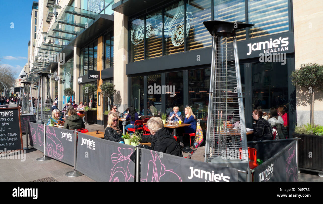 La gente seduta ai tavoli pasti fuori Jamie's Italian Restaurant Cardiff City Centre, Wales UK KATHY DEWITT Foto Stock