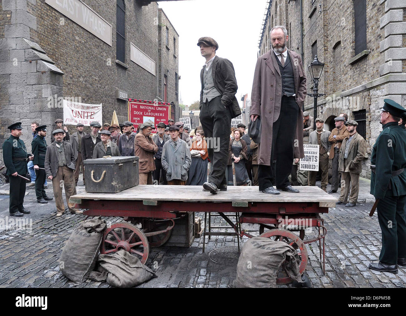 Liam Cunningham sul televisore di 'Titanic: Sangue e acciaio" le riprese in location a Dublino dove egli si rivolge a un ampio gruppo di Foto Stock