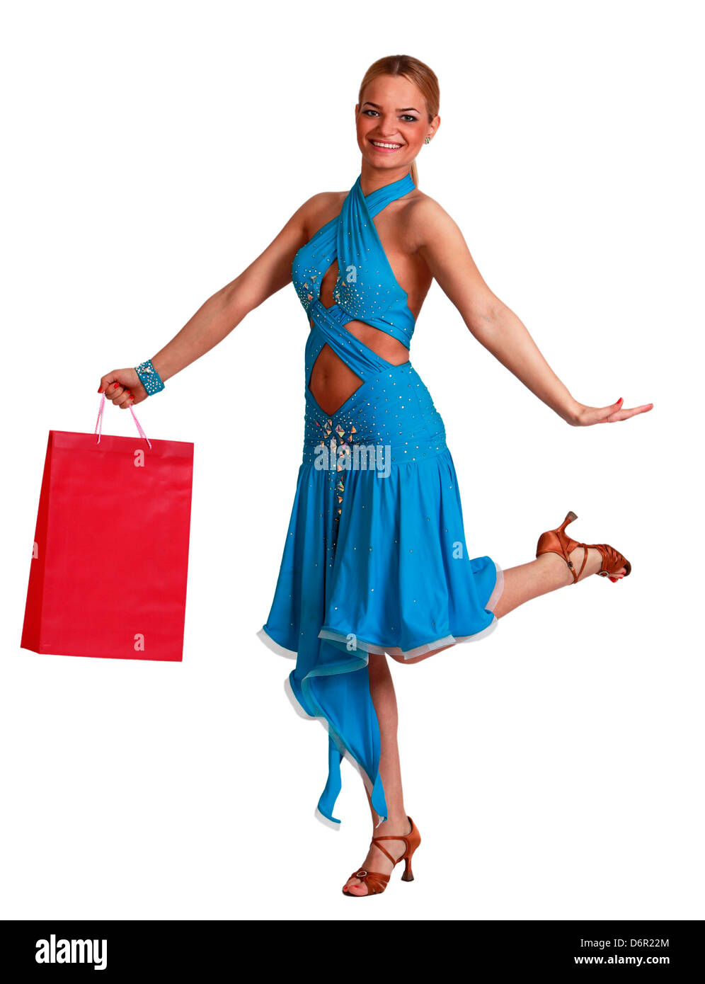 Felice giovane donna bionda in un abito di fantasia con shopping bag jumping contro uno sfondo bianco. Foto Stock