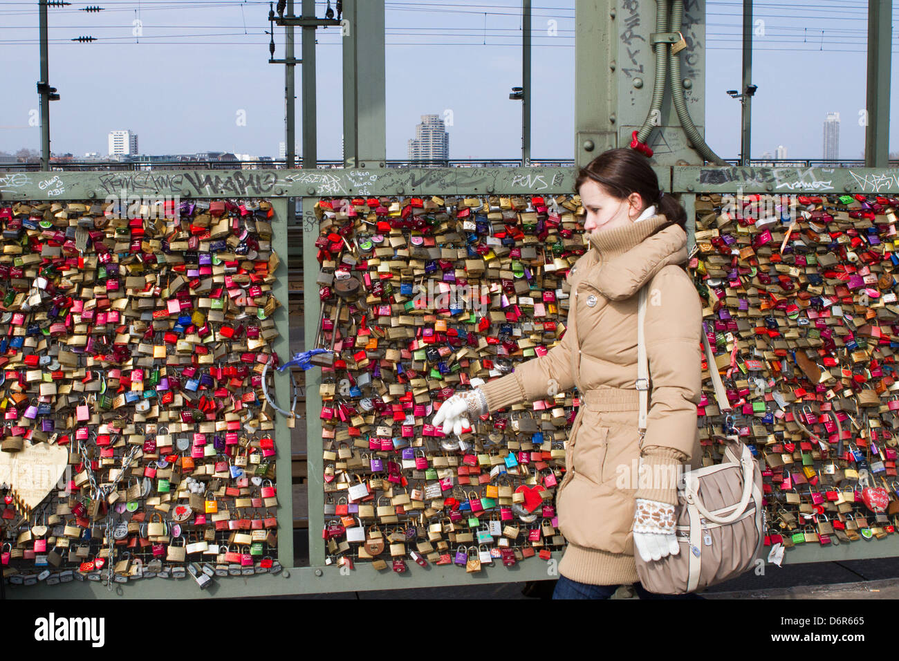 Donna cammina passato Ppdlocks su Colonia ponte ferroviario a significare ing coppie' amore gli uni per gli altri Foto Stock