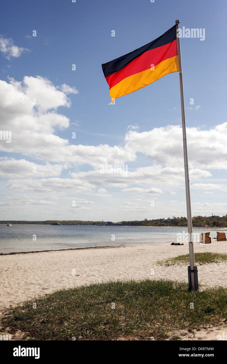 Eckernfoerde, Germania, pennone con bandiera della Germania sulla spiaggia Foto Stock