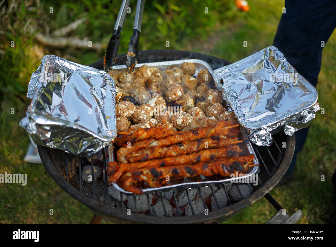 Emden, Germania, su una griglia a carbone in un foglio piatto sono carne e torce Hackbaellchen Foto Stock