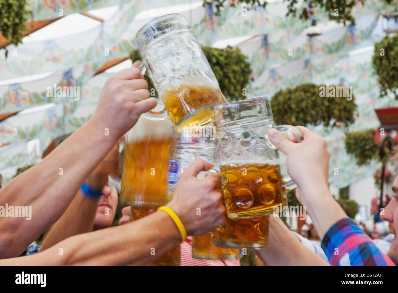 La gente la tostatura con birre durante l'Oktoberfest Monaco di Baviera, Germania Foto Stock