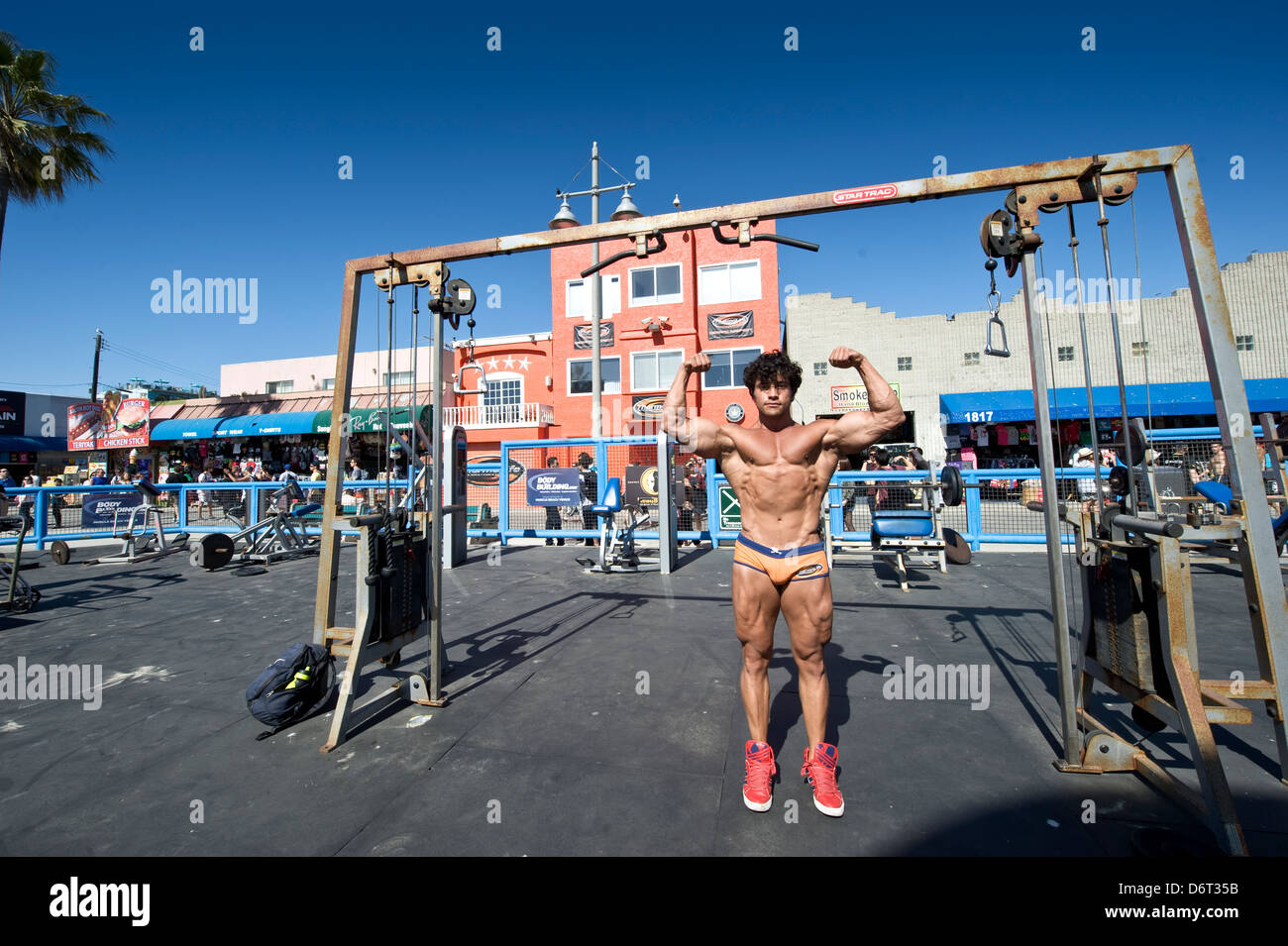 La spiaggia di Venezia, Santa Monica, California, Stati Uniti d'America: un culturista mette in mostra i suoi muscoli Foto Stock