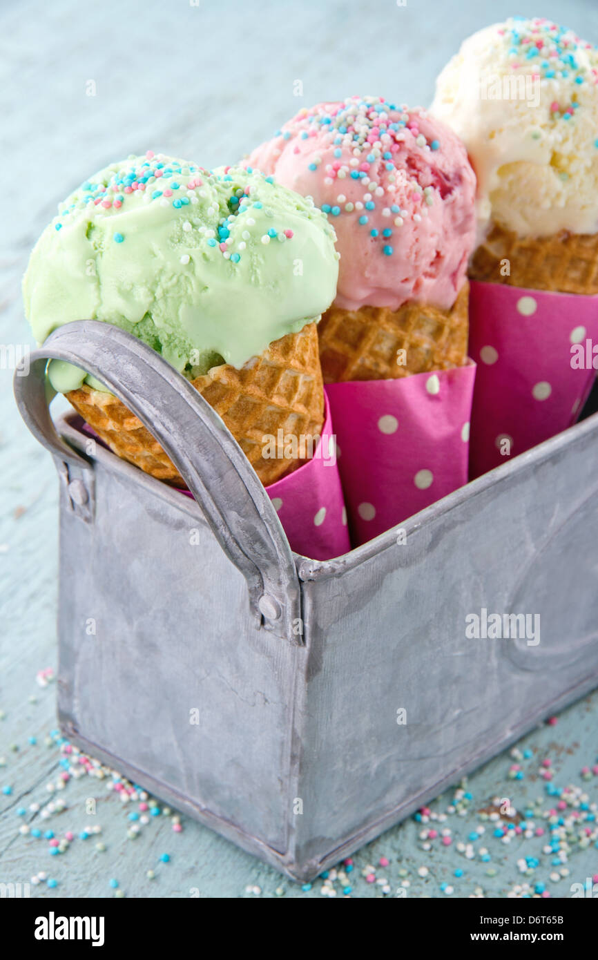 Coni gelato in un cestello di metallo in azzurro shabby chic sfondo vintage Foto Stock