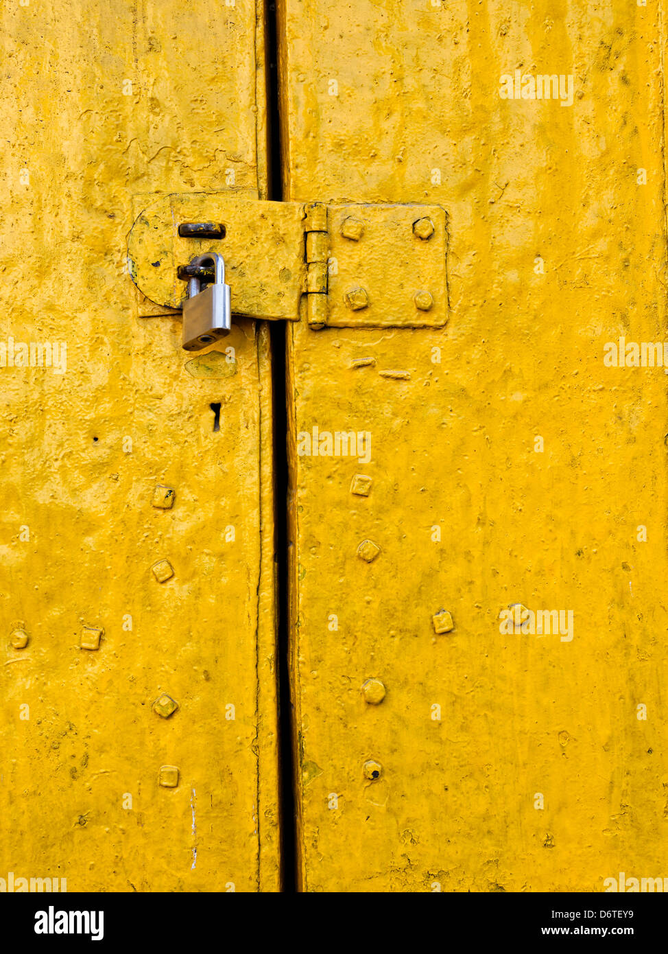 Lucchetto su un vecchio giallo sportello metallico Foto Stock