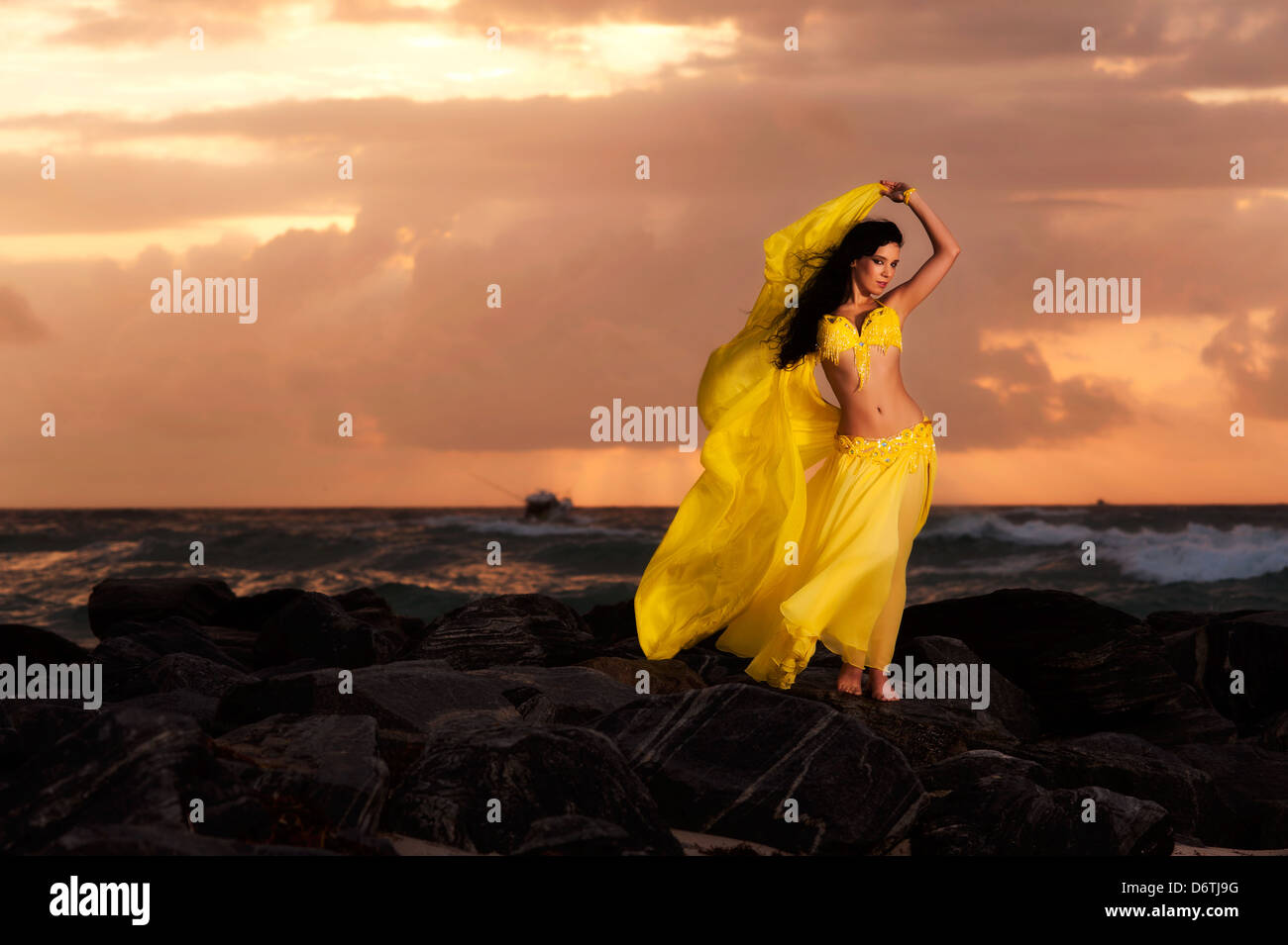 Una danzatrice del ventre in Costume Giallo sulla spiaggia di Sunrise Foto Stock