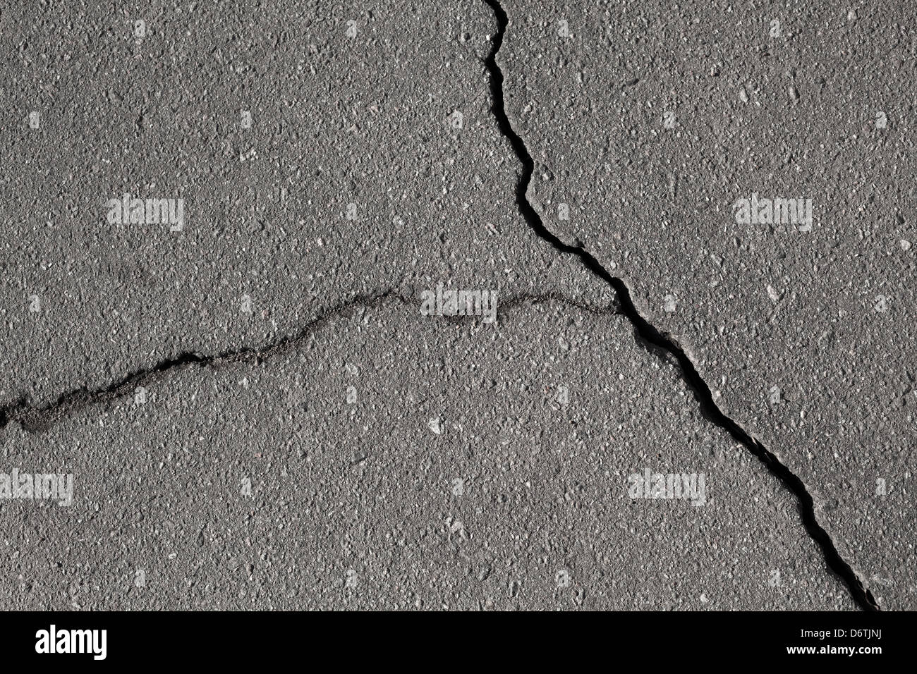 Closeup texture di danni al manto stradale in asfalto con incrinature Foto Stock