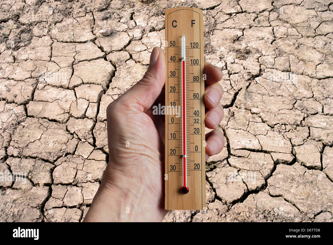 Mano che tiene un termometro che indica il cambiamento climatico a causa dell aumento delle temperature su scala mondiale. Foto Stock