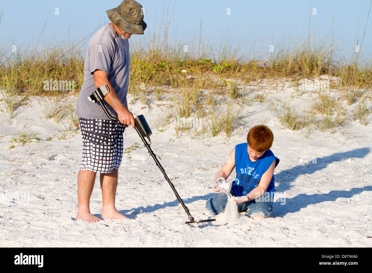 Padre e figlio utilizzando un rivelatore di metalli in spiaggia sulla costa del Golfo della Florida, Stati Uniti d'America. Foto Stock