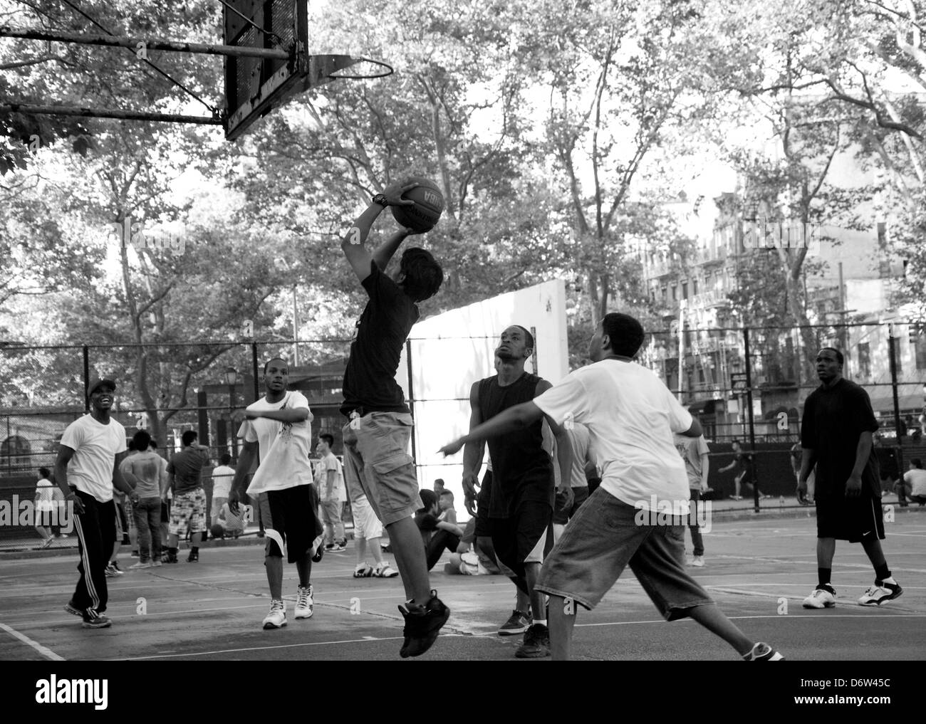 Giovani uomini giocare a basket in un parco nella Chinatown di New York City, Stati Uniti d'America Foto Stock